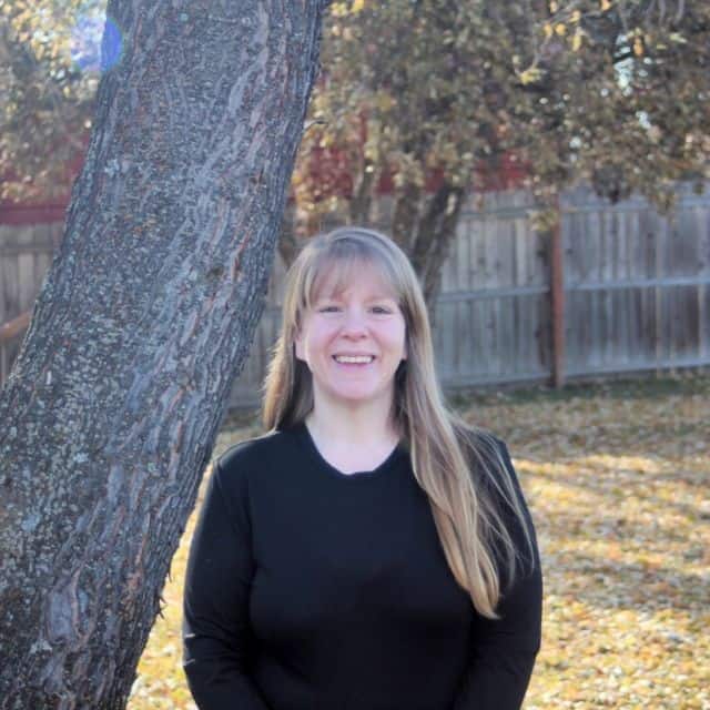 A photo of Kathie Lapcevic standing next to a tree.